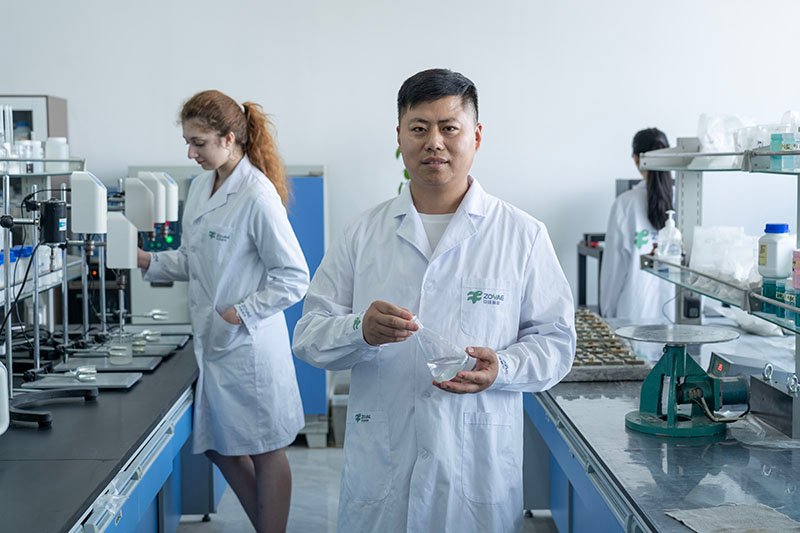 Team of chemists in lab coats analyzing formulations in a modern lab